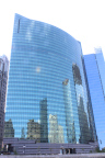 Photo of a wide building with the chicago skyline reflected in its windows