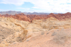 Photo of yellow sedimentary rock formations in the foreground and red sedimentary rock formations in the background