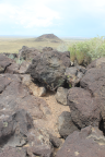 Photo of basalt rocks in foreground and inert volcano in background